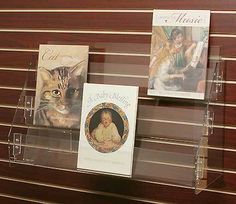 there are three books on display in the glass case and one has a cat's face