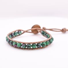 This single wrap leather bracelet is adjustable and has a second loop allowing some extra length. Size: Adjustable from ~6.5-7in         >First Loop at ~6.5inches         >Second Loop at ~7inches Beads: 6mm Stone Beads         >Green/Pink   Clasp: Coconut Button          >Brown Leather: Round Leather Cord         >Brown Thread: Upholstery Thread          >Brown *Photos are taken with care to ensure the color is portrayed correctly. However, due to different screen resolution, screen brightness, lighting, etc... from phone screens to computer screens, colors in the bracelet may differ slightly than pictured. If you have any questions, please don't hesitate to message me. Hand Wrapped Friendship Bracelet With Round Beads, Adjustable Hand Wrapped Leather Wrap Bracelet, Adjustable Hand-strung Leather Bracelet With Round Beads, Adjustable Hand Wrapped Leather Bracelet With Round Beads, Adjustable Hand-wrapped Beaded Leather Bracelet, Bohemian Leather Wrap Bracelet, Adjustable, Bohemian Leather Wrap Bracelet Adjustable, Bohemian Adjustable Leather Wrap Bracelet, Adjustable Leather Bohemian Wrap Bracelet