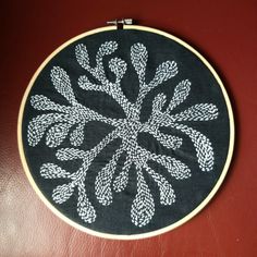 a black and white embroidery on a red surface