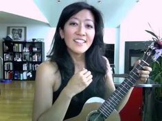 a woman holding a ukulele in her right hand