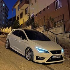 a white car is parked on the street