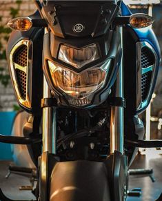 the front end of a motorcycle with its lights on and headlamps turned on