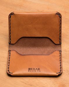 a brown leather wallet sitting on top of a wooden table