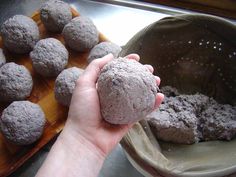 a hand holding a gray ball of food