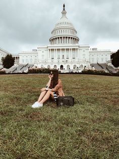 a woman sitting in front of the capitol building