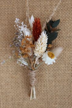 a bunch of flowers sitting on top of a burlap tablecloth covered floor