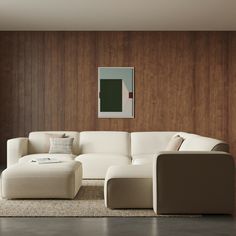 a modern living room with white furniture and wood paneling on the wall behind it