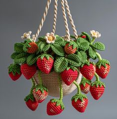 strawberries hanging from a rope with leaves and flowers