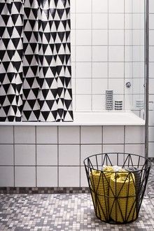 a bathroom with black and white tiles and a basket full of gold coins next to the bathtub