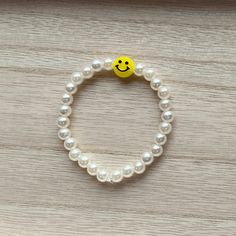 This bracelet is Smiley Pearl! It includes a yellow charm, that is very bright and stylish! The bracelet string used is 5-6 1/2 inches long, this string is stretchy and is able to fit many different wrist sizes! If a different size is needed please add a note to your order. This item is made with pearls and a smiley face charm. The smiley face charm may rub off over time. Yellow Stretch Bracelet As A Gift, Trendy Yellow Stretch Bracelet With Round Beads, Casual Yellow Beaded Bracelets, Casual Hypoallergenic Yellow Jewelry, Cute Yellow Stretch Bracelet As A Gift, Cute Yellow Stretch Bracelet For Gift, Cute Yellow Stretch Bracelet Gift, Casual Yellow Hypoallergenic Jewelry, Cute Yellow Bracelet For Everyday Wear