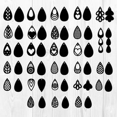 a collection of black and white drops on a wooden background, each with different designs