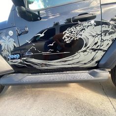 the side view of a vehicle painted with an image of a wave and palm trees