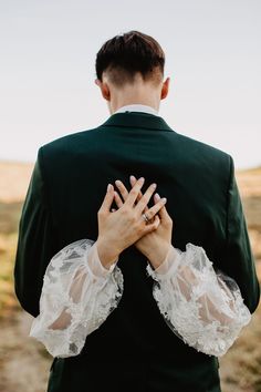 a man in a green suit holding his hands together