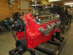 a red engine sitting on top of a metal stand