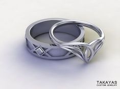 two wedding rings with intertwined designs on them, sitting next to each other in front of a white background