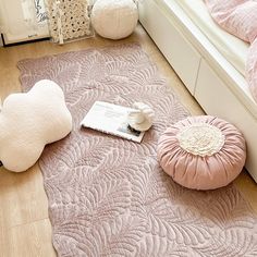 a bedroom with pink bedding and pillows on the floor