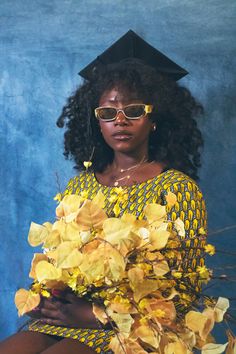 a woman wearing sunglasses and holding flowers