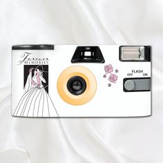 a white camera with pink roses on the front and black lens attached to it's body