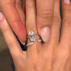 a woman's hand with two engagement rings on it and one ring in the middle