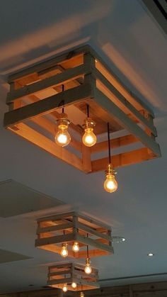 some lights that are hanging from the ceiling in a room with wood beams and light bulbs