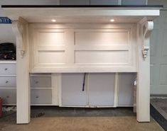 a white desk with drawers underneath it in a room that is being built into the wall