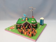 a birthday cake with candy candies and a carnival tent on it's side