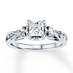 an engagement ring with three stone diamonds on the shoulders and side stones in the band