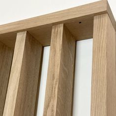 a close up view of the wood frame on a wooden shelf with white walls in the background