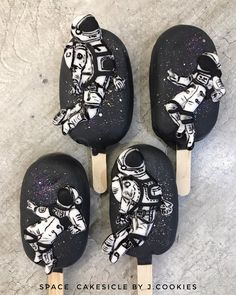 four black and white popsicles with astronaut designs on them