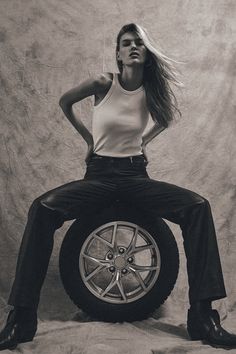 a woman sitting on top of a tire