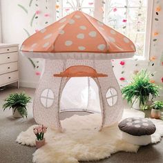 a pink and white tent with polka dots on it in a child's room