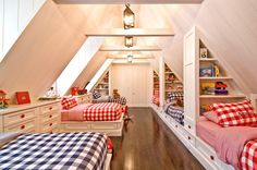 two beds in a room with red and white checkered sheets on them, next to each other