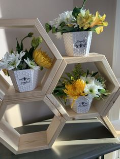 three hexagonal wooden shelves with flowers in them