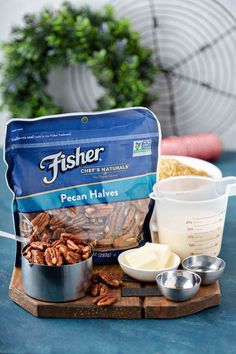 pecan halves, butter and other ingredients are sitting on a cutting board next to a measuring cup