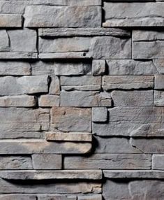 a stone wall that is made out of grey bricks