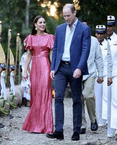 prince william and kate are walking down the path with other people in uniform behind them