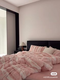 a bed covered in pink blankets and pillows