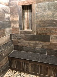 a tiled shower with a bench in the corner