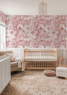 a baby's room with pink and white wallpaper