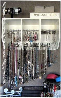 a display case filled with lots of necklaces and jewelry hanging from it's sides