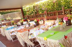 an outdoor dining area with tables, chairs and flowers on the tablecloths are arranged in rows