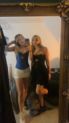 two beautiful young women standing in front of a mirror