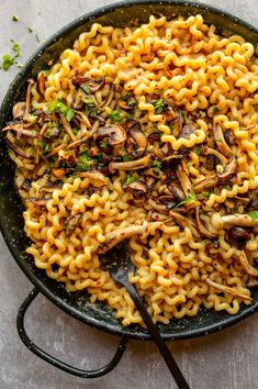 a skillet filled with pasta and mushrooms on top of a white table next to the words spicy miso pasta