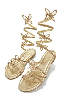 Step into the Fantasy sandals, made for special occasions. The sleek gold tone design is accented by butterfly patches embellished around the ankle coil. The sandals have a lightly padded interior for an extra comfortable fit. Look your best with this stylish sandal. Stock Unit: 27A1 SIZE & FIT Shoe Model Suggestio Gold Embellished Flat Sandals, Gold Embellished Ankle Strap Sandals, Gold Flat Heel Sandals For Spring, Glamorous Gold Beach Sandals, Glamorous Gold Flat Sandals, Gold Embellished Round Toe Sandals, Gold Embellished Sandals With Round Toe, Gold Outfit Aesthetic, Prom Gold