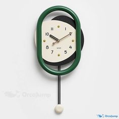 a green and white clock hanging on the wall