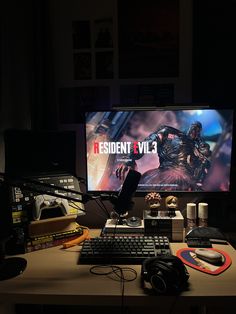 a desk with a monitor, keyboard and headphones on top of it in the dark