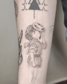 a person with a tattoo on their arm holding a small child's head and wearing a hat