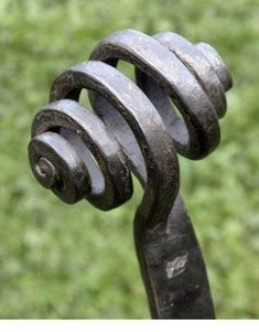 a close up of a metal object on the ground with green grass in the background