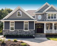 a house with gray siding and white trim on the front door, windows, and porch