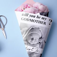 a bouquet of pink flowers next to a folded card with the words, will you be my godmother?